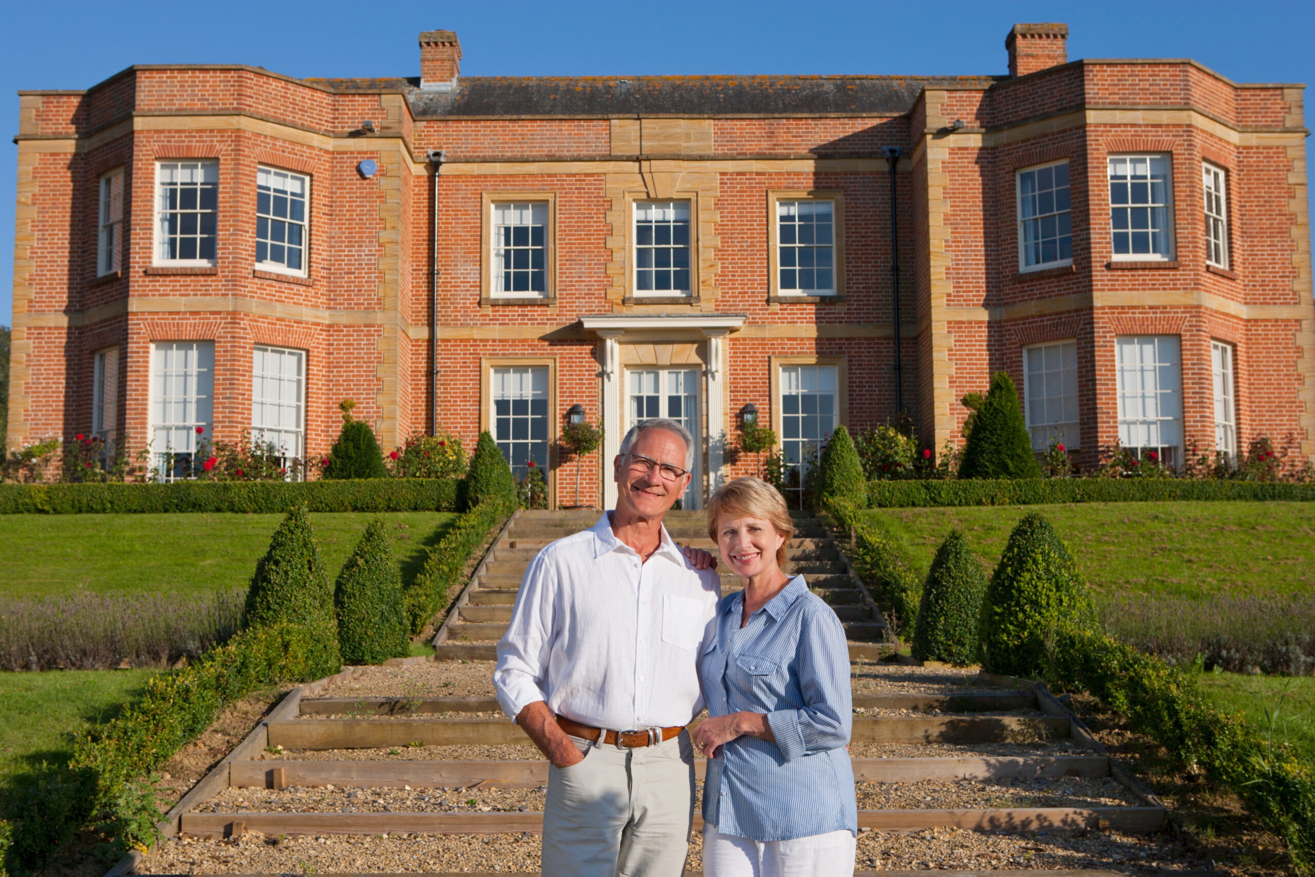 senior couple standing in front of brick senior living facility