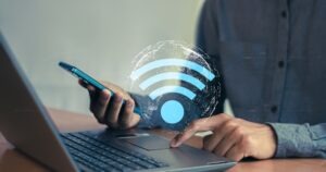 man and laptop behind a wifi icon